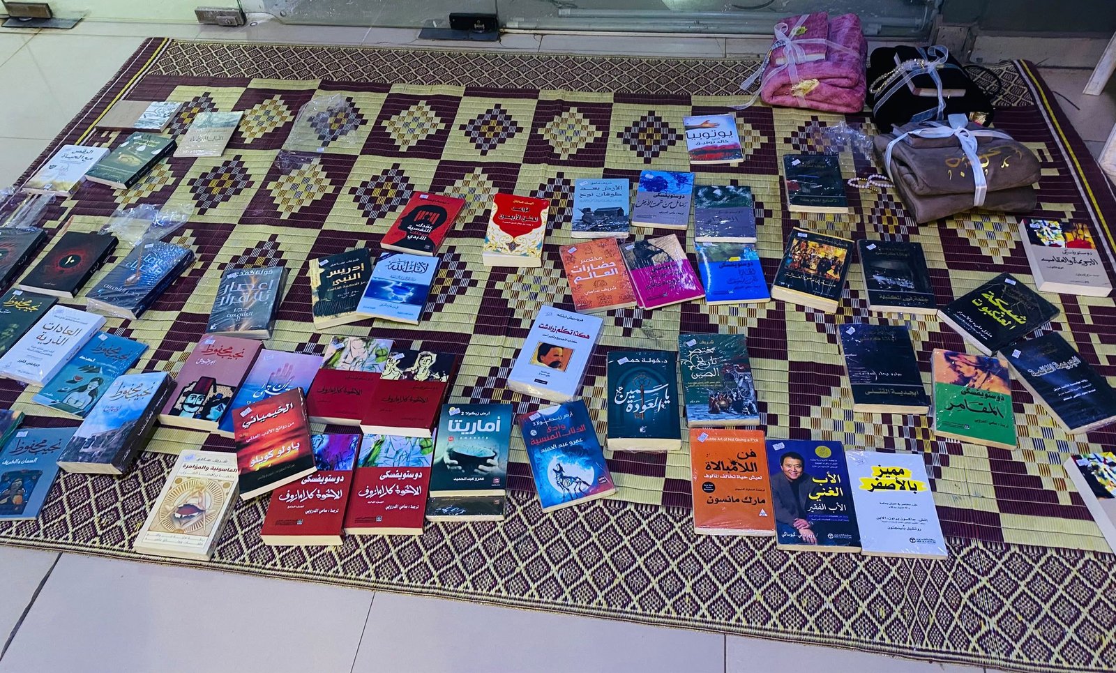 كتب عربية معروضة فوق فرشة في فعالية مفروش بكمبالا.